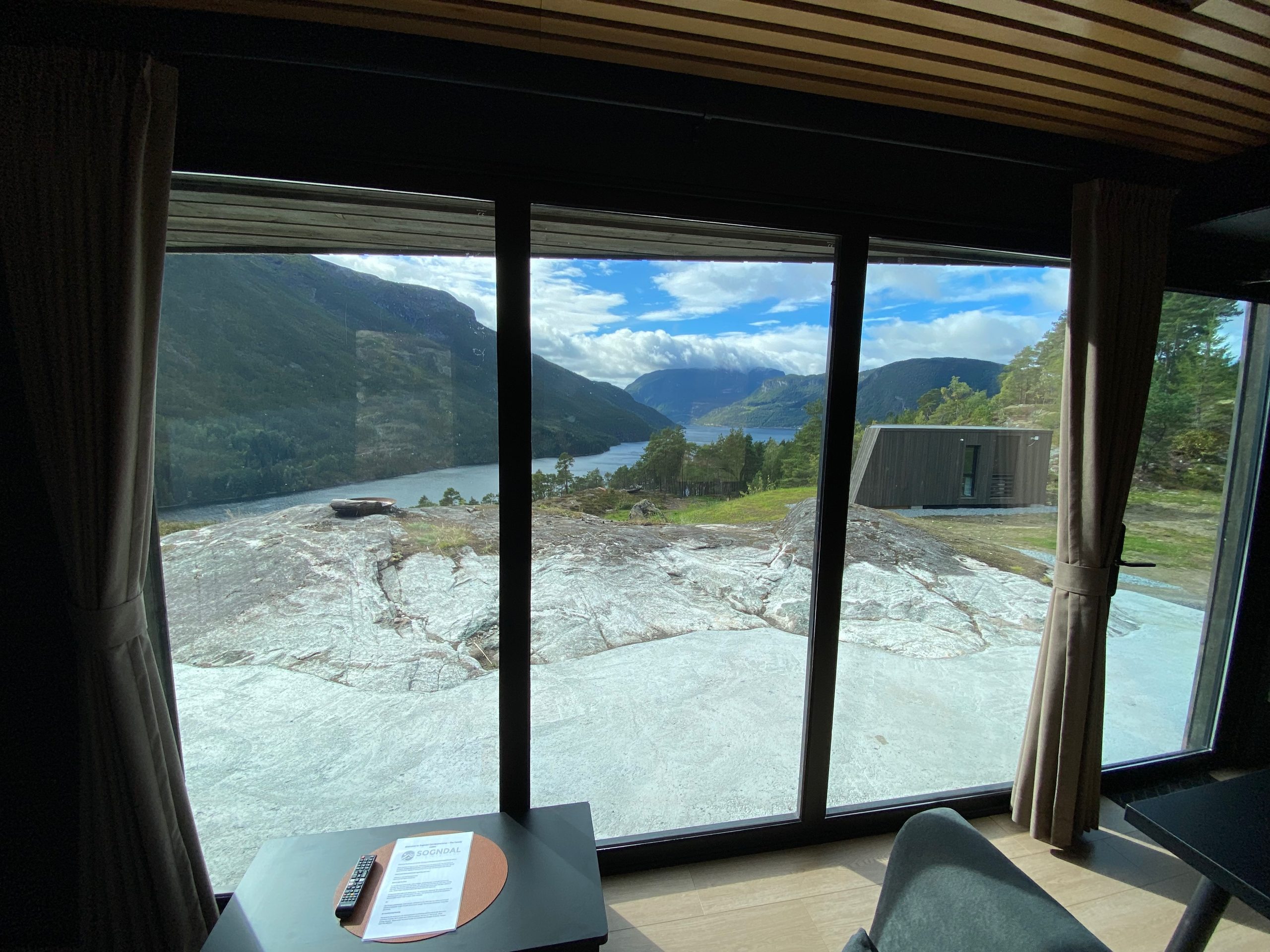 View from inside Sogndal Fjordpanorama cabin during a Sogndal Fjordpanorama Review, with large windows overlooking the fjord and mountains in Norway