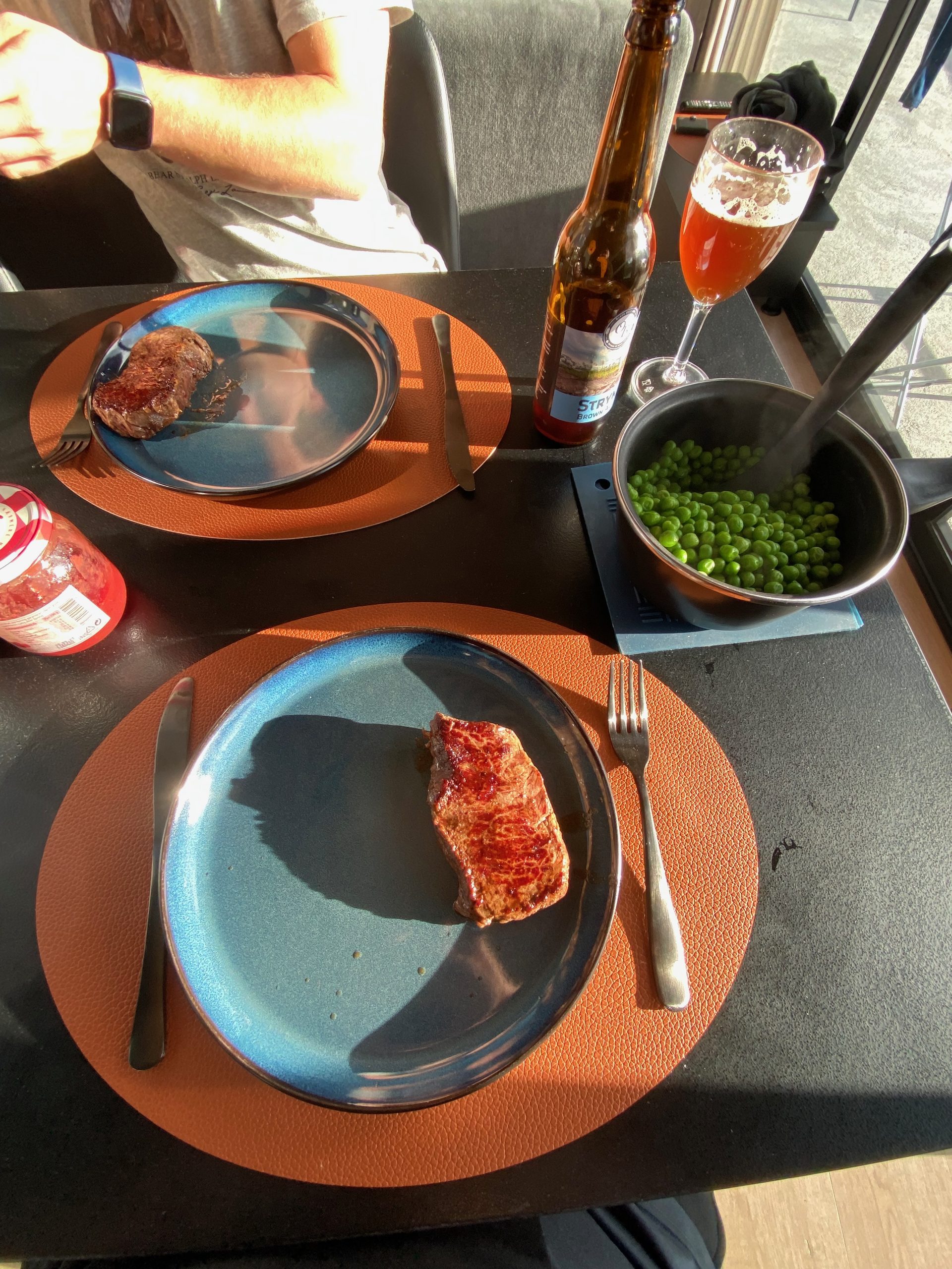Homemade cabin dinner with steak, green peas, beer, and tomato sauce during a Sogndal Fjordpanorama Review in Norway