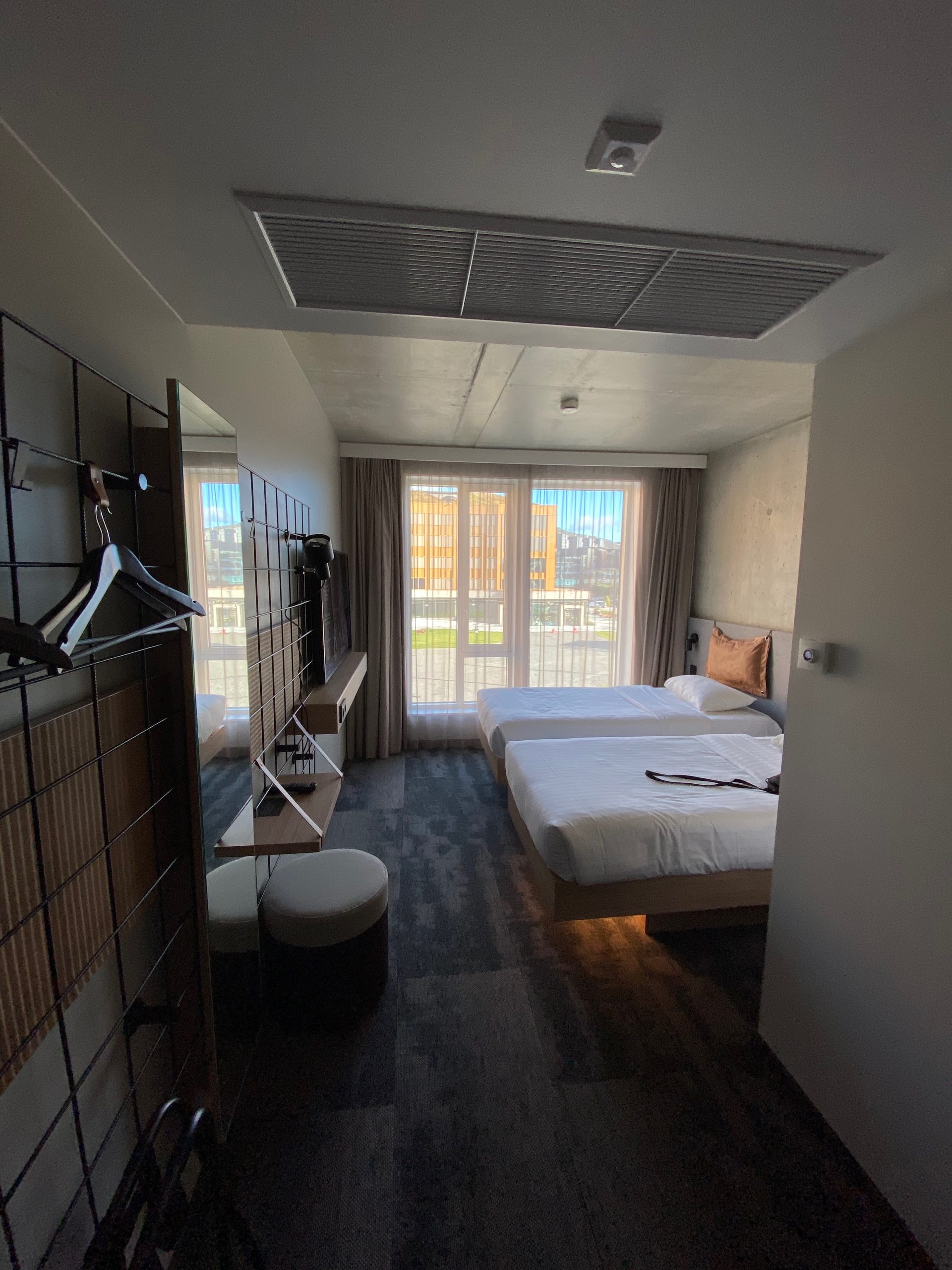Moxy Hotel Bergen room 221 with two separate beds, industrial interior, large window, and modern hotel design