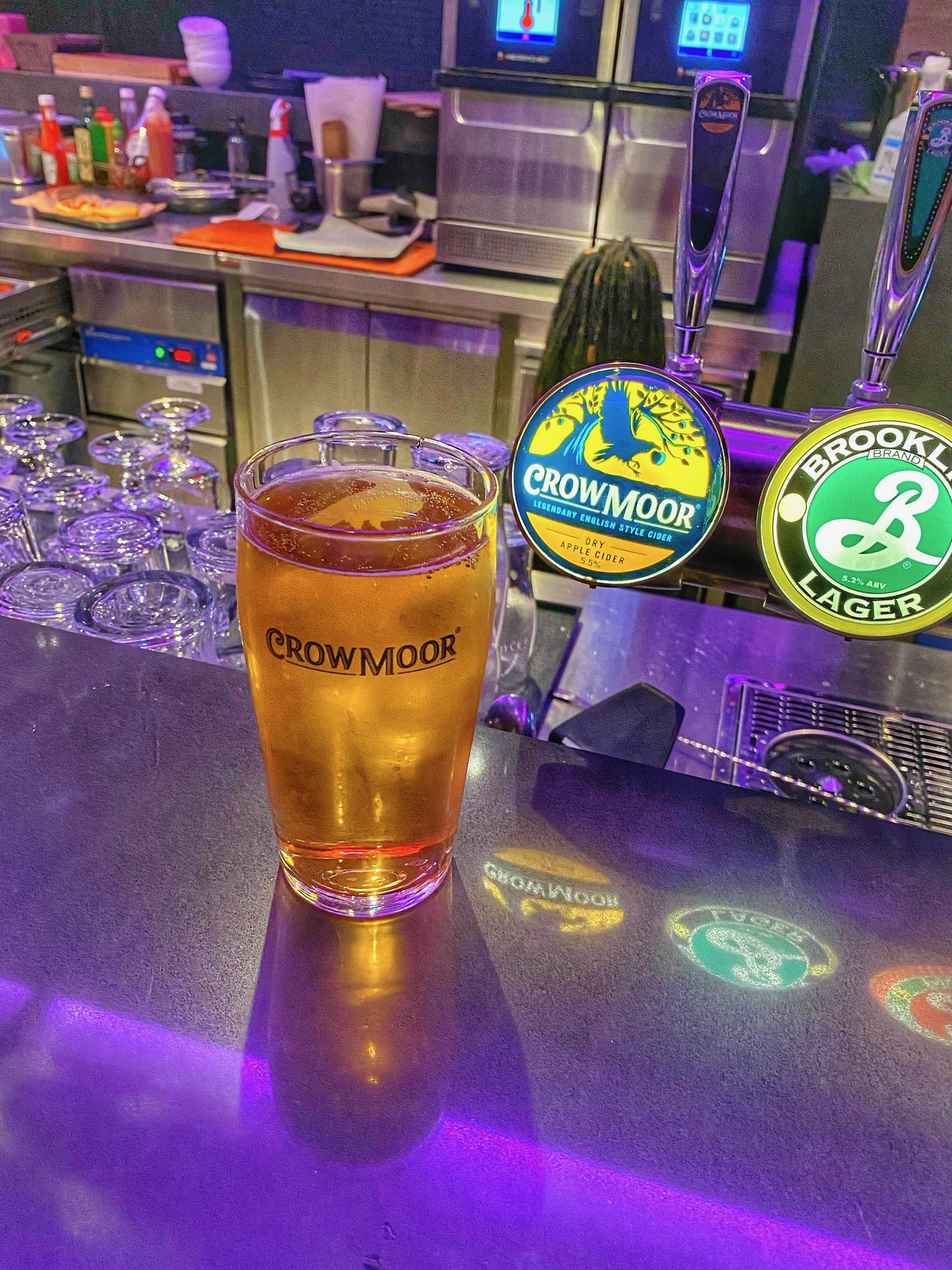 Moxy Hotel Bergen bar with Crowmoor apple cider, beer taps, and purple lighting in the modern hotel lounge