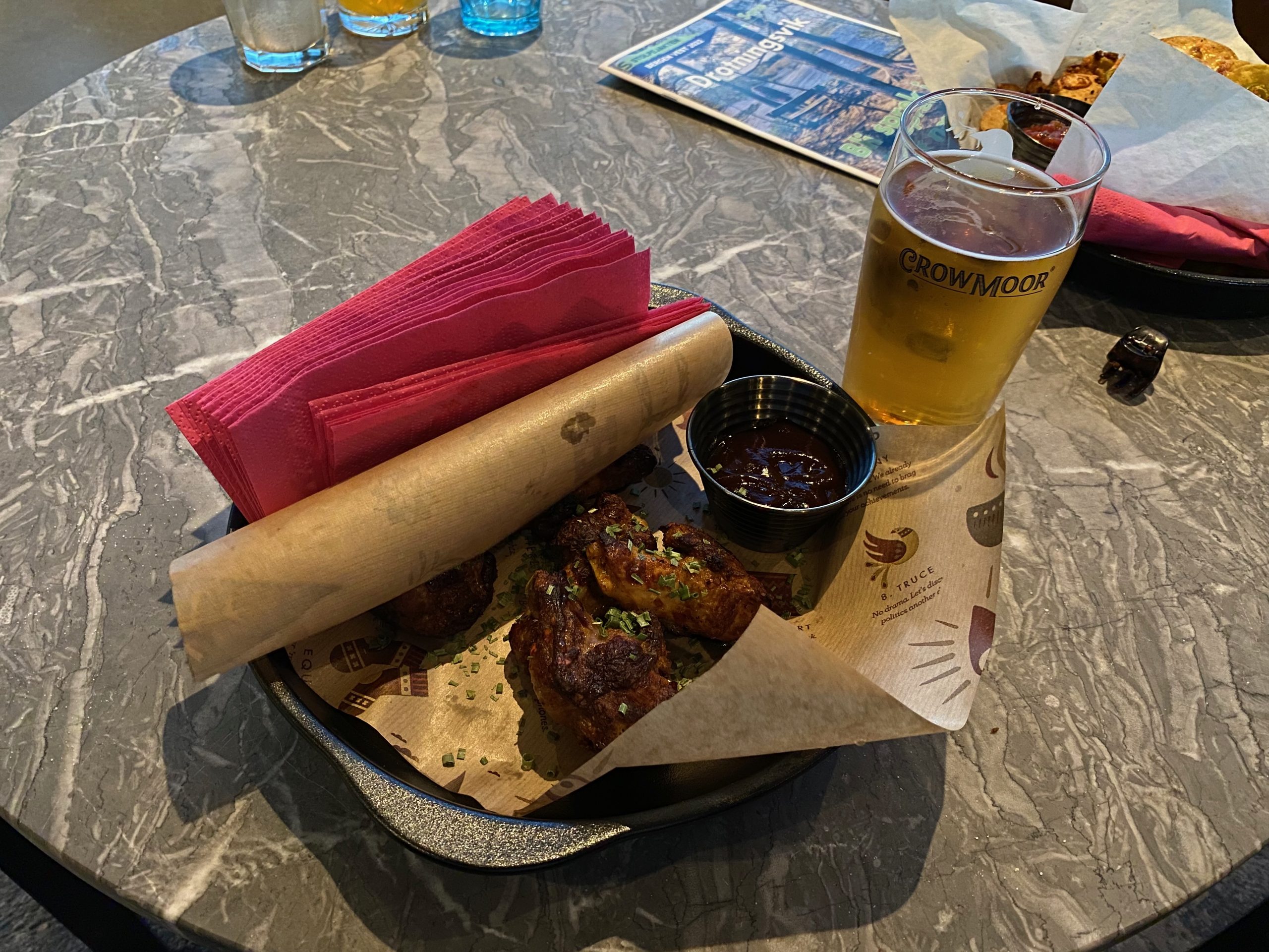 Moxy Hotel Bergen late night snack with chicken wings, dipping sauce, nachos, and Crowmoor cider in the hotel bar