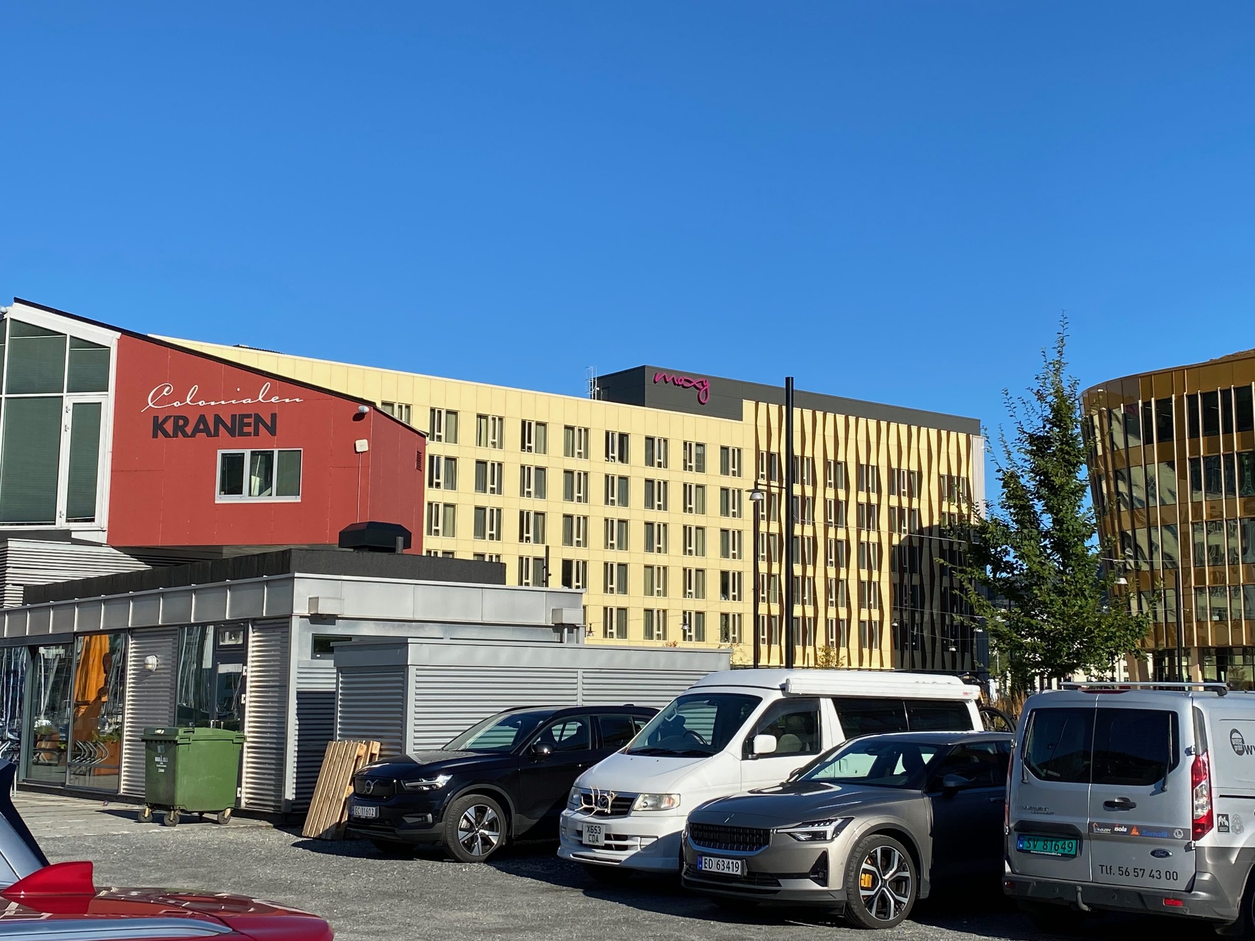 Moxy Hotel Bergen viewed from the nearby parking area with the modern hotel building and parked cars in Bergen, Norway