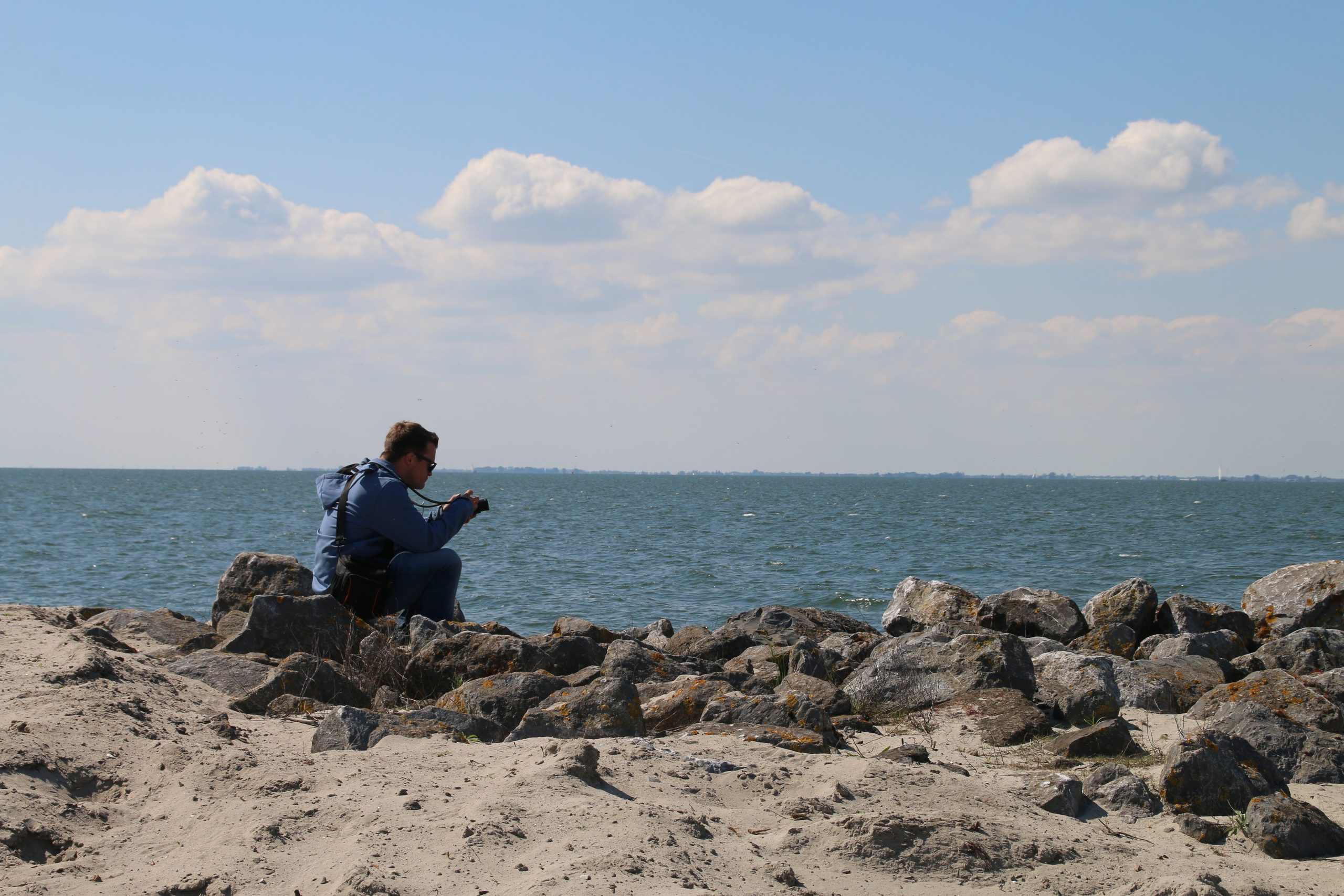 Marker Wadden island visit with a visitor Peter Smit photographing the Markermeer from the rocky freshwater beach