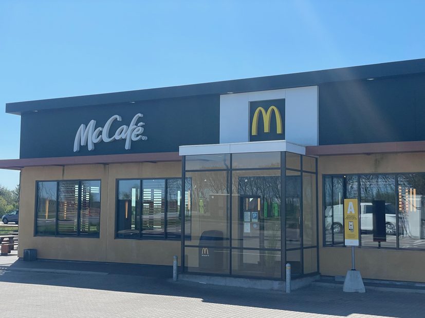 McDonald's Brønderslev exterior with the McCafé logo, golden arches entrance and modern roadside restaurant building at Velkomstcenter Syd 3 in Denmark