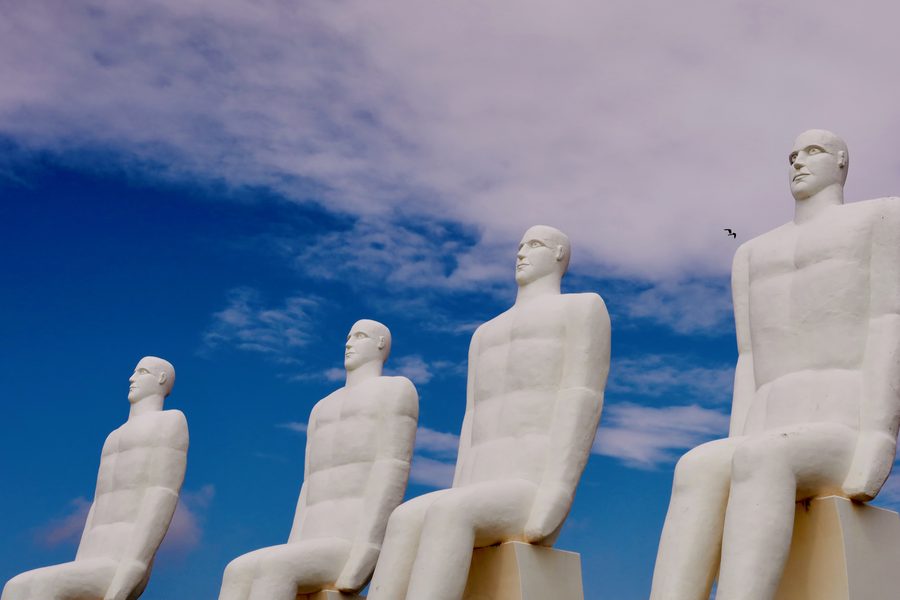 Mennesket ved Havet in Esbjerg Denmark with four white statues looking over the sea under a dramatic blue sky